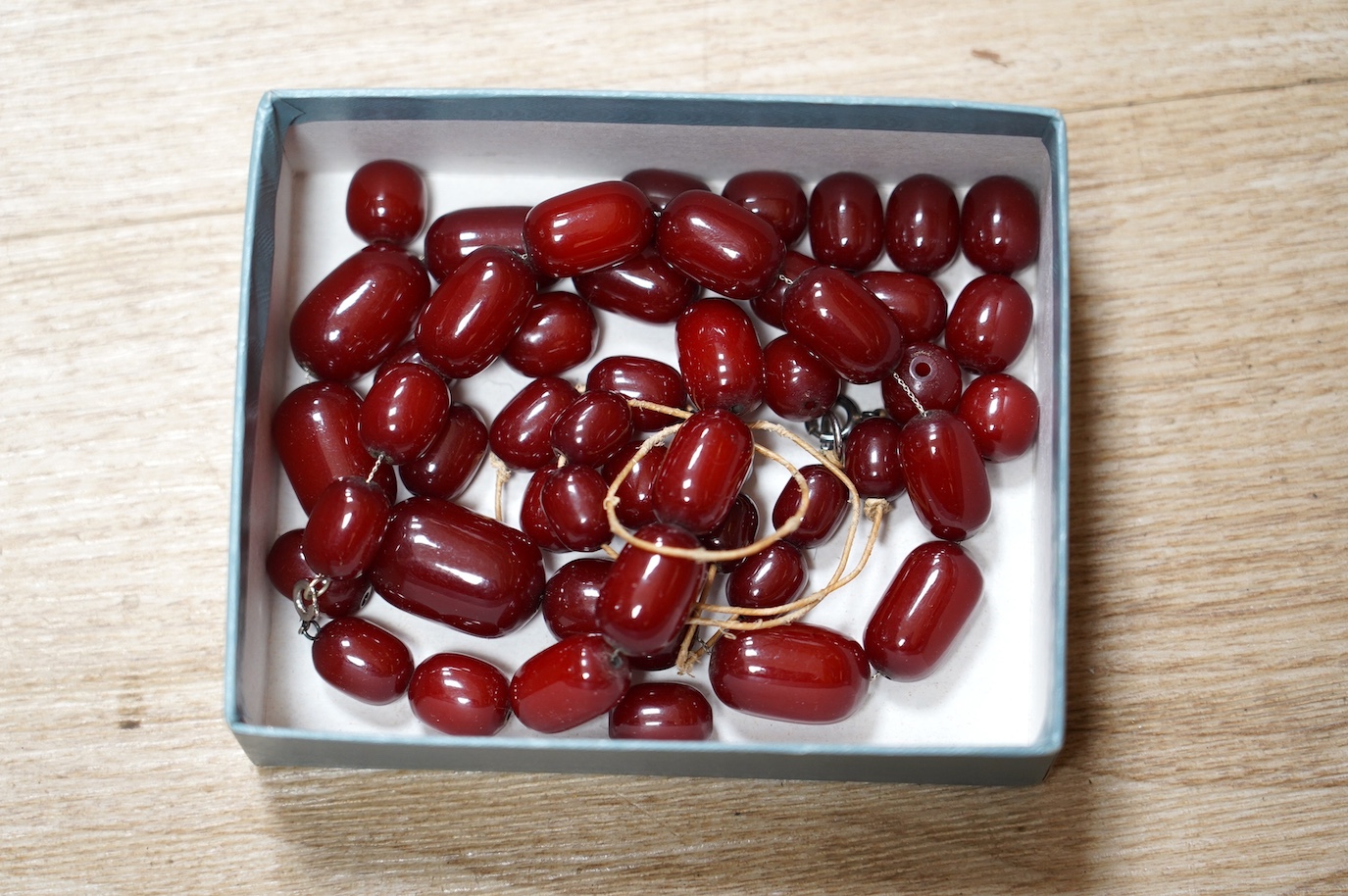 A simulated cherry amber bead necklace, (needs re-stringing), gross weight 136 grams. Condition - poor